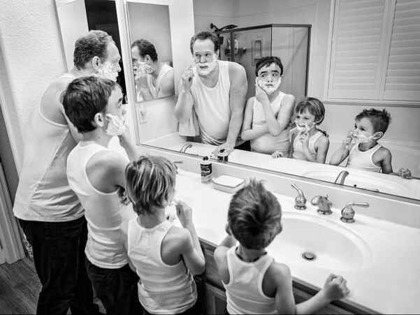 black and white of dad with three sons shaving