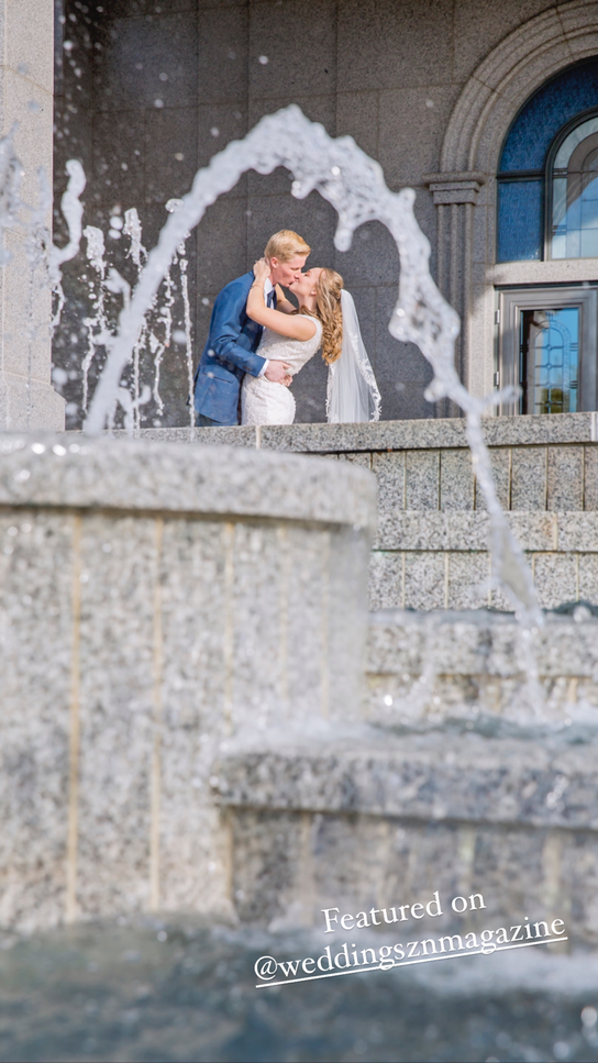 bride and groom kissing through a fountain