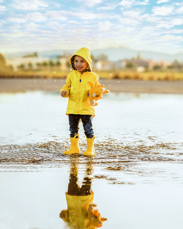 boy in yellow jacket and boots landing in puddleom/contact.html