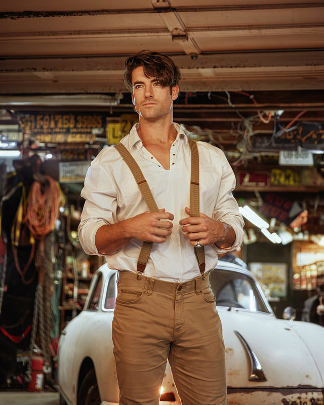 Man in suspenders standing in garage