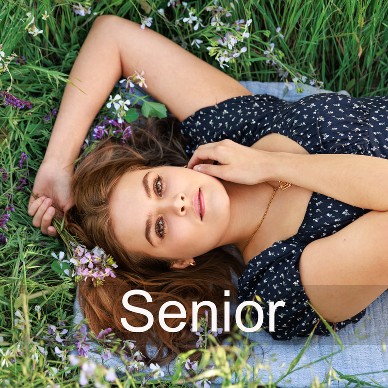 high school senior girl laying on flower field