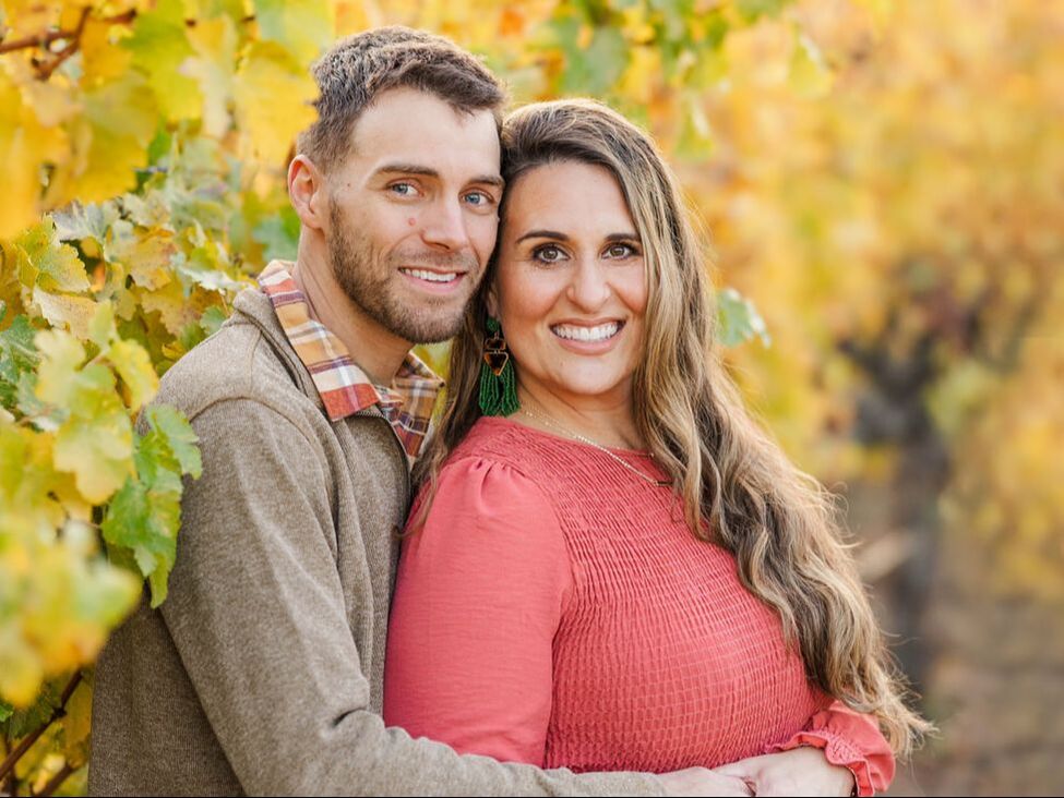 male and female couple holding each other in a vineyard