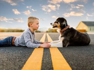 publication photo of boy and dog laying in the street