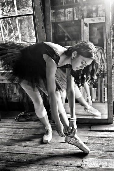 black and white of ballet dancer putting on slipper