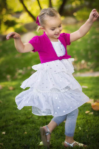 young girl in white dress and pink top dancing