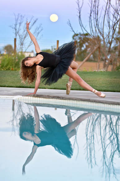 ballet dancer in black tutu with pool reflection