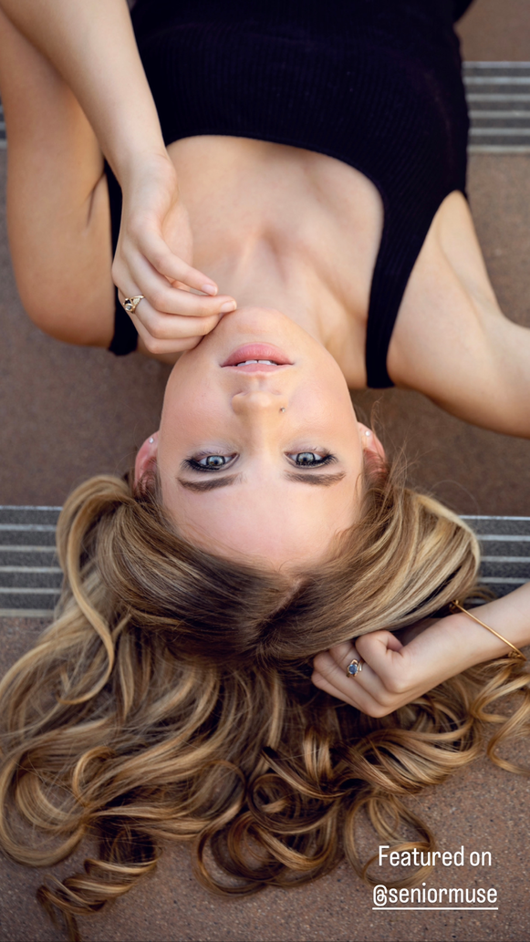 teenage girl with long blond hair laying down on stairs