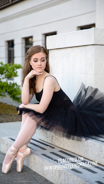teenage girl with long brown hair and black tutu sitting on step resting head on one hand