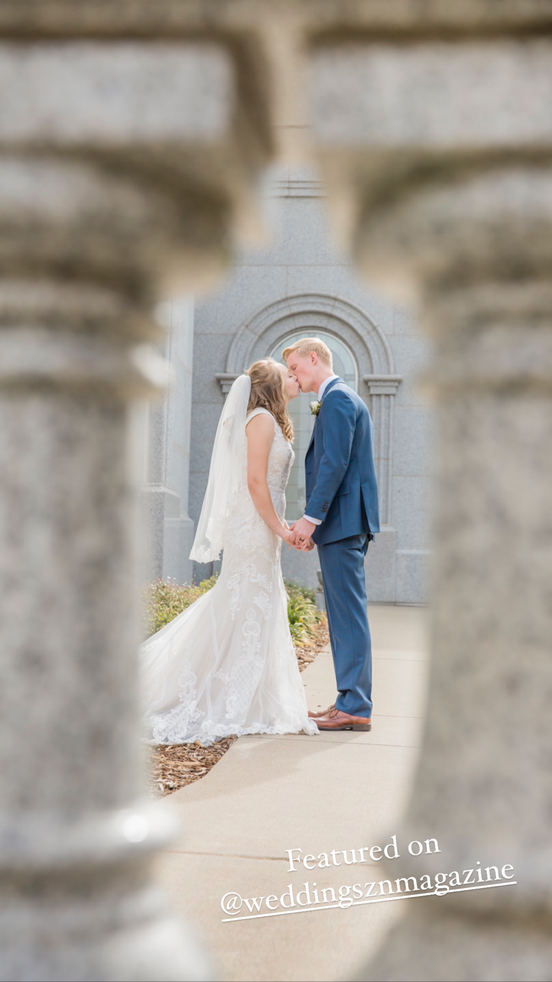 bride and groom kissing through a column