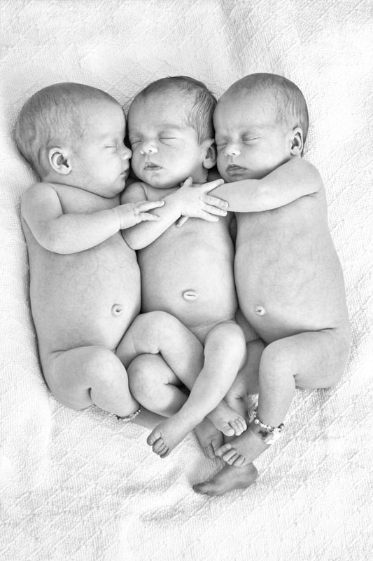 triplets embracing each other asleep