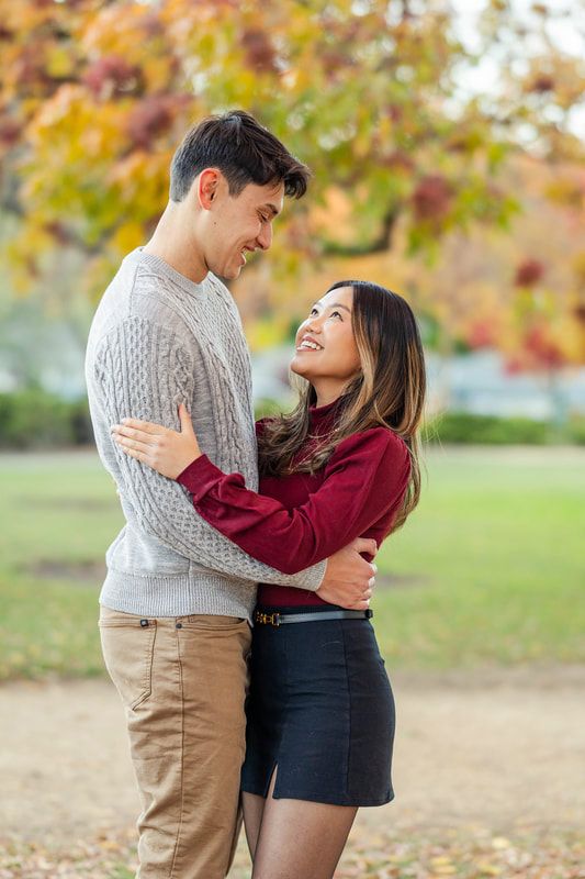 Young male and female couple facing each other smiling