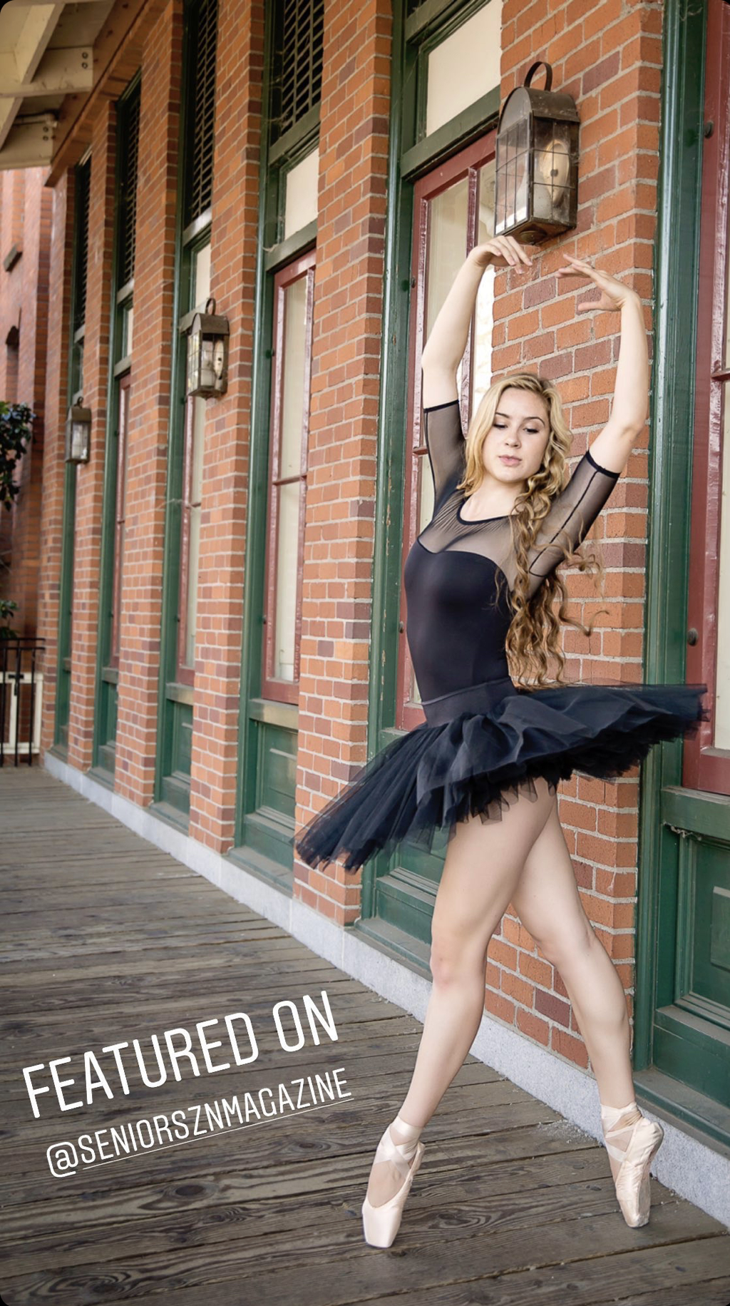 teenage girl with long blonde hair in a black tutu with arms up