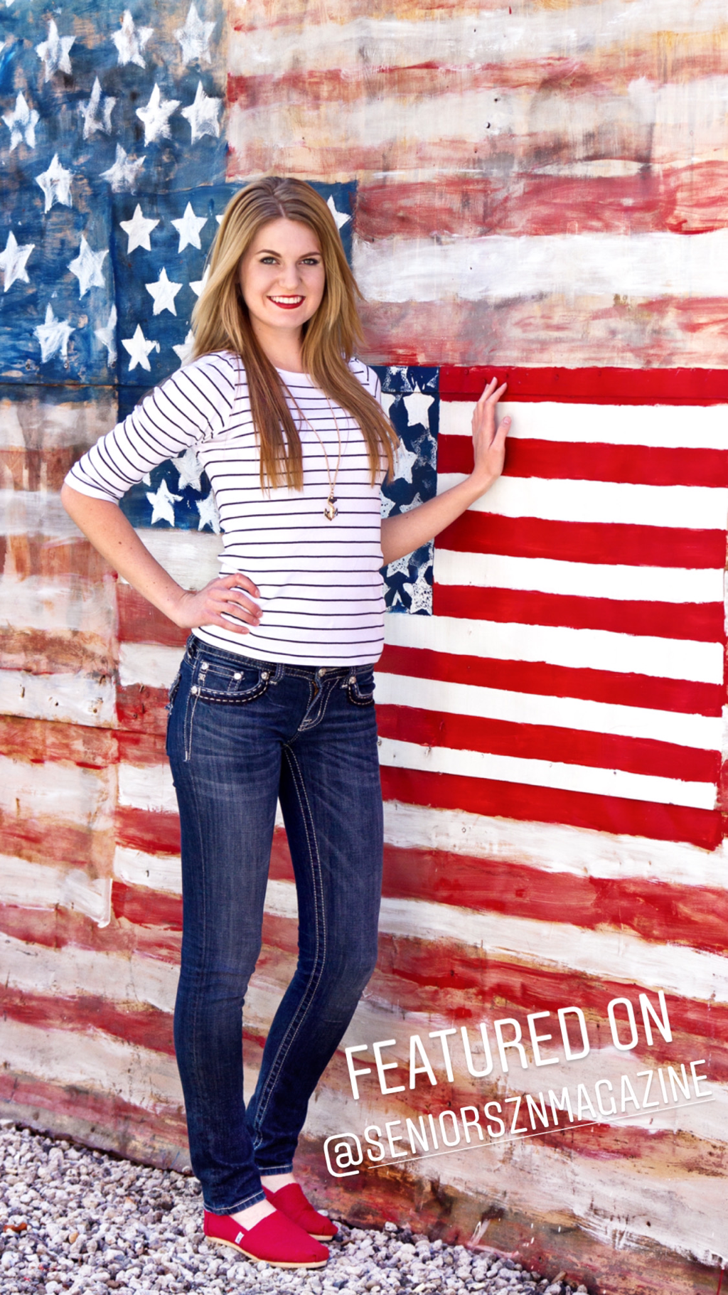teenage girl with long blond hair and blue jeans standing next to US flag painting wall
