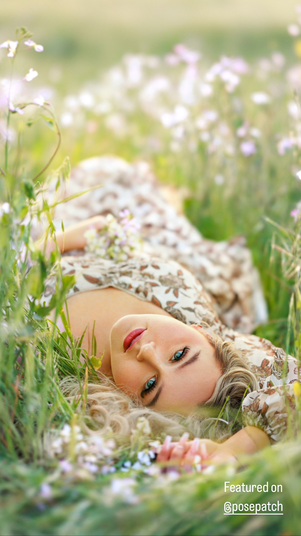 teenage blond girl in floral long dress laying in the grass