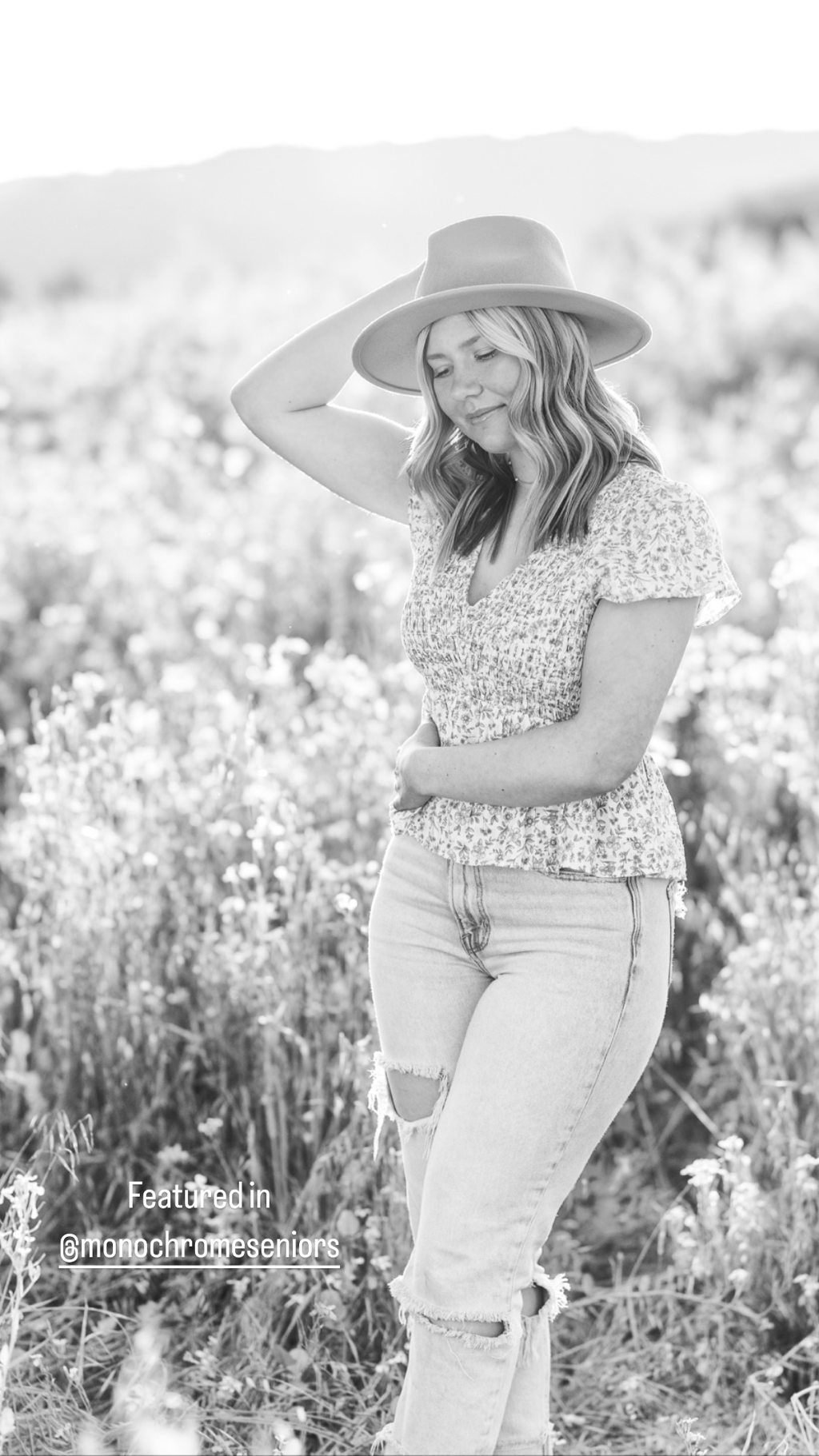 teenage girl with long blond wearing a hat and jeans in a flower field