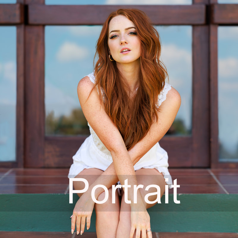 portrait of red head model sitting in white jumper with arms crossed