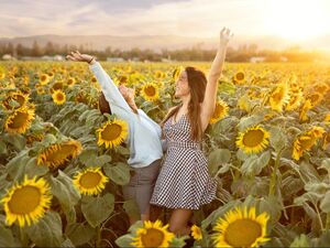 feature of two teenage girls in sunflower field