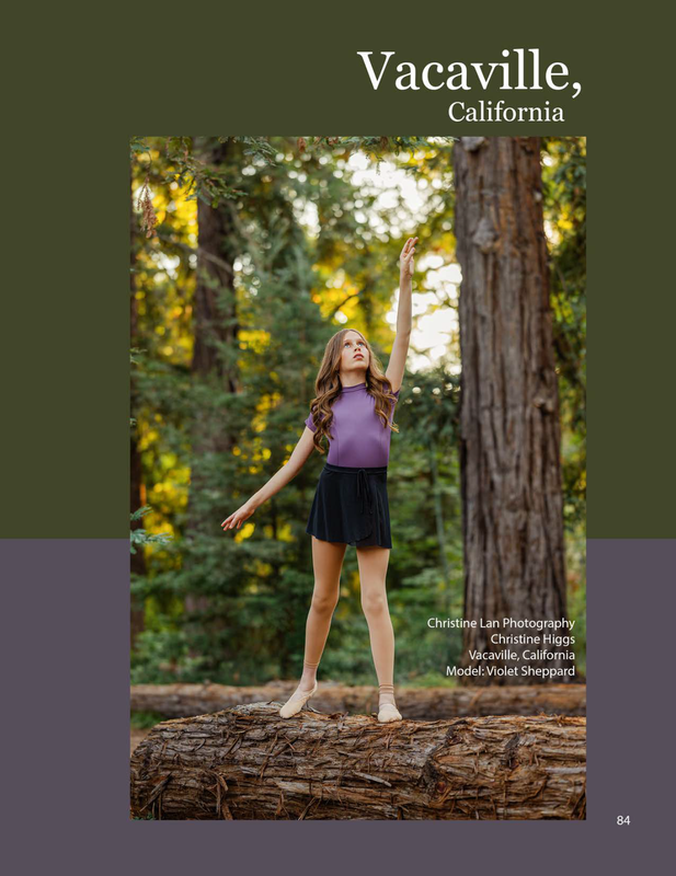 Girl in black ballet skirt and purple leotard standing on redwood tree log reaching up withe on arm
